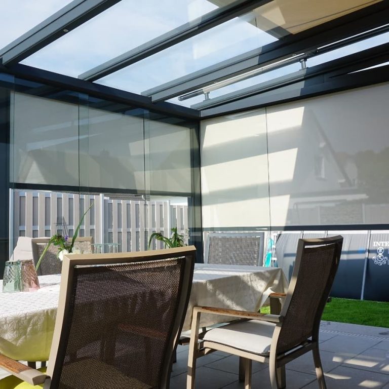 Moderne Terrasse mit einer Überdachung und beigen Markisenstoff. LEWENS Aufglasmarkise sowie LEWENS Senkrechtmarkisen