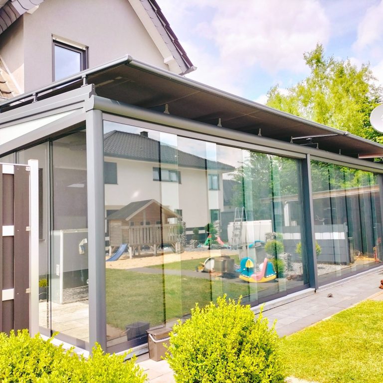 Ganzglas-Schiebesystem als Windschutz für Terrassendach